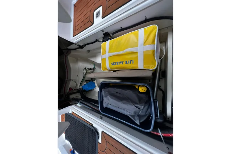 Slide: The Image of 2025 Ranger Tugs R-27 storage compartment with safety equipment and gear. - 16