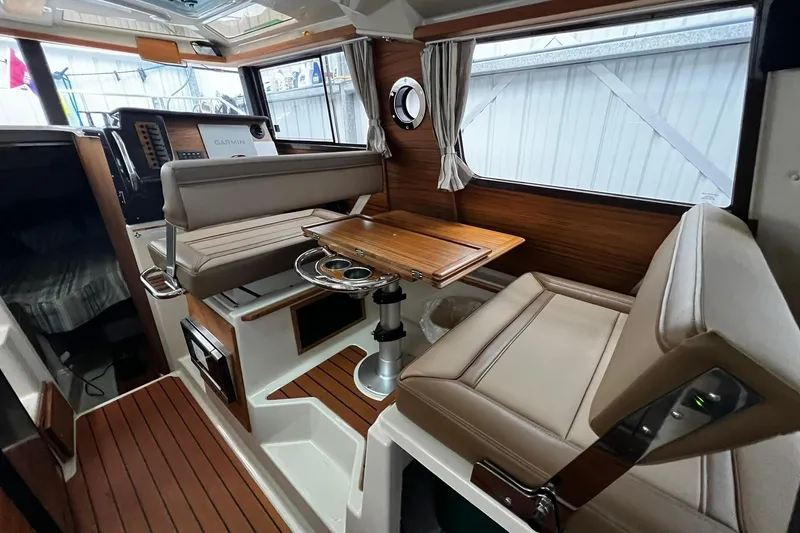 Slide: The Image of 2025 Ranger Tugs R-27 interior with wood accents and seating area. - 19