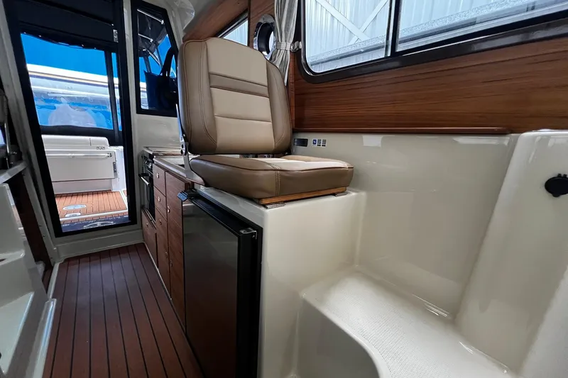 Slide: The Image of 2025 Ranger Tugs R-27 interior with leather seating and wood accents. - 25