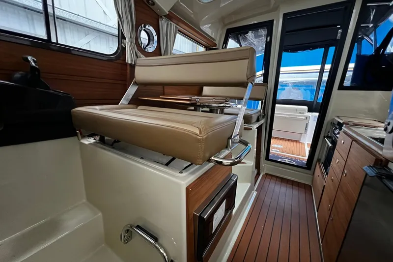 Slide: The Image of Interior of 2025 Ranger Tugs R-27 boat with seating and wooden flooring. - 26