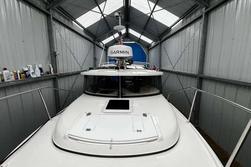 Slide: The Image of 2025 Ranger Tugs R-27 boat in a metal storage shed with Garmin equipment. - 4