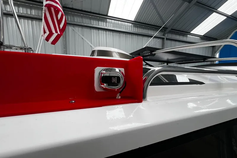 Slide: The Image of 2025 Ranger Tugs R-27 boat detail with American flag in a metal-roofed storage. - 8