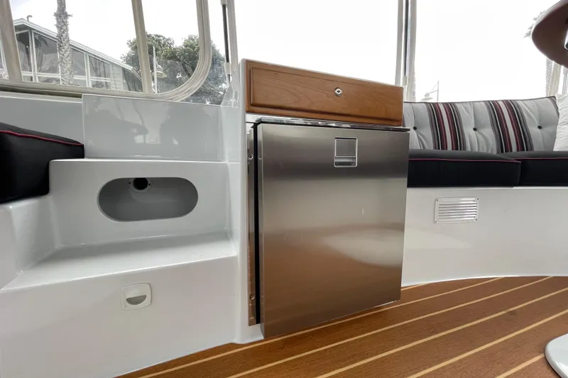 Slide: The Image of Interior of 2020 Duffy Snug Harbor 18 with seating, fridge, and wood flooring. - 12