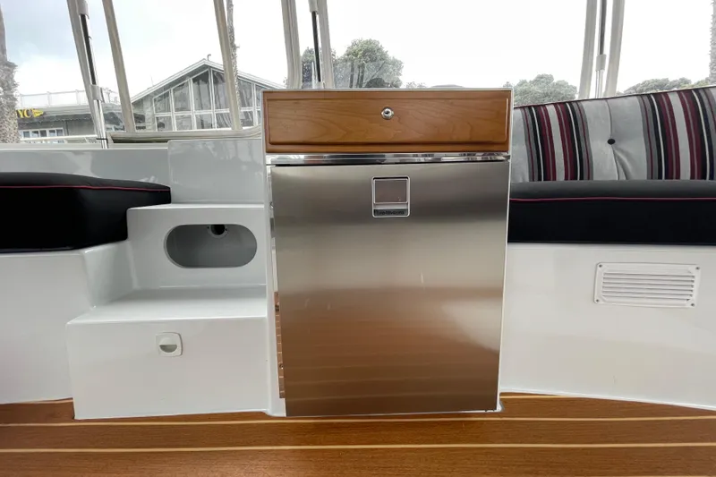 Slide: The Image of Interior of 2020 Duffy Snug Harbor 18 with stainless steel fridge and striped seating. - 13