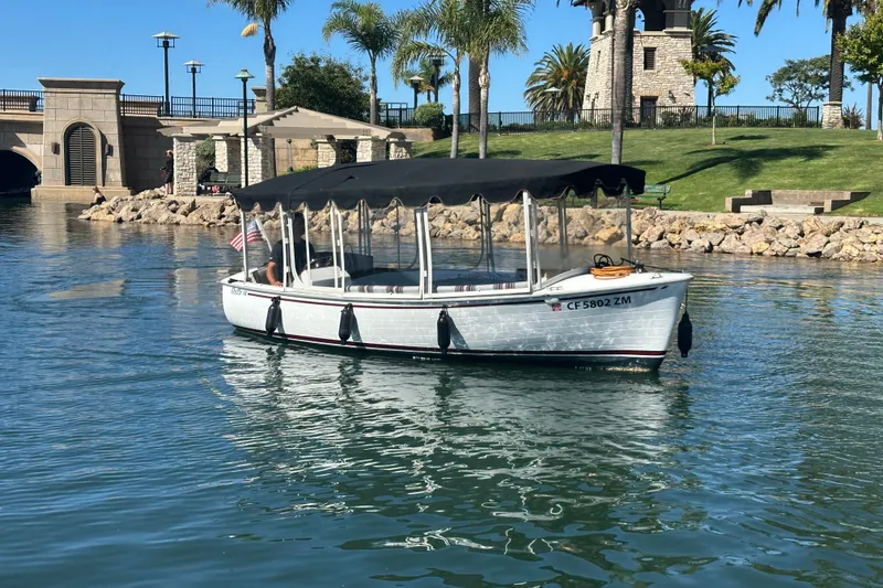 Slide: The Image of 2020 Duffy Snug Harbor 18 boat cruising near a scenic waterfront park. - 2