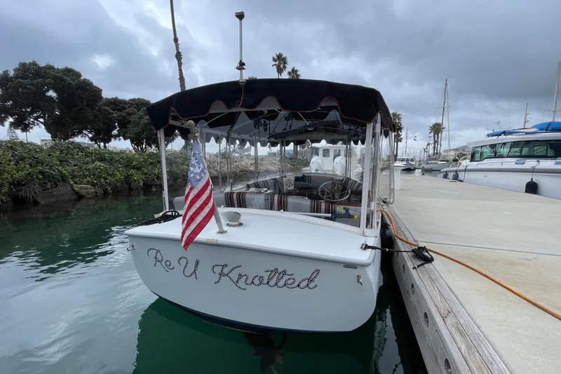 Slide: The Image of 2020 Duffy Snug Harbor 18 boat docked, displaying an American flag and "Re U Knotted" text. - 5