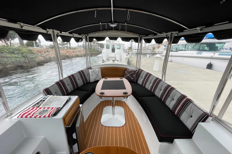 Slide: The Image of Interior of 2020 Duffy Snug Harbor 18 boat with striped seating and wooden flooring. - 7