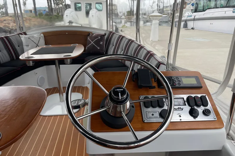 Slide: The Image of 2020 Duffy Snug Harbor 18 boat interior with steering wheel and control panel. - 9
