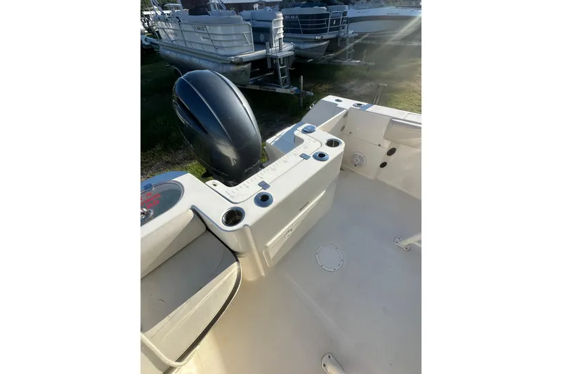 Slide: The Image of 2023 Sailfish 220 CC boat interior with motor, cup holders, and seating area. - 20