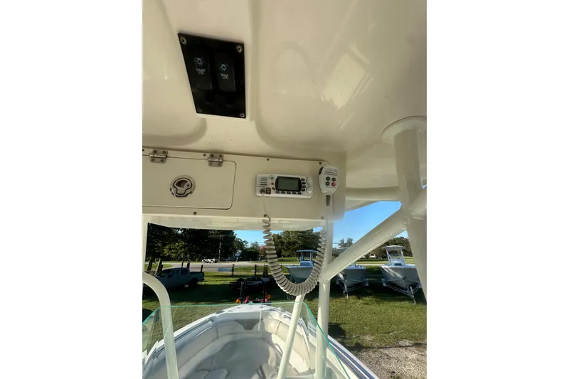 Slide: The Image of 2023 Sailfish 220 CC boat console with radio and controls, parked outdoors. - 25