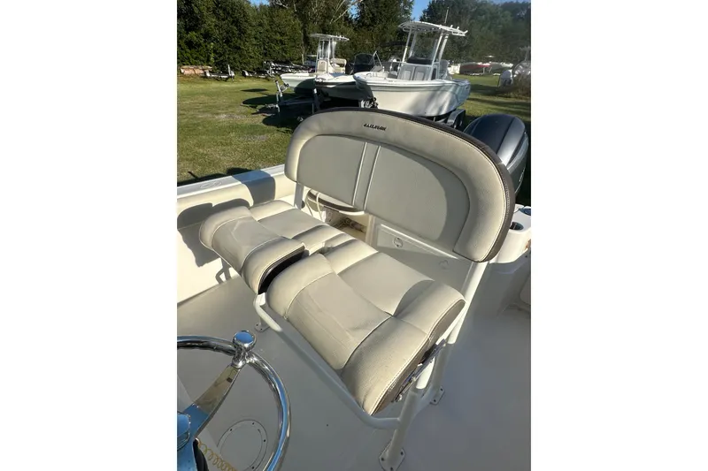 Slide: The Image of 2023 Sailfish 220 CC boat interior with cushioned seating and steering wheel. - 27