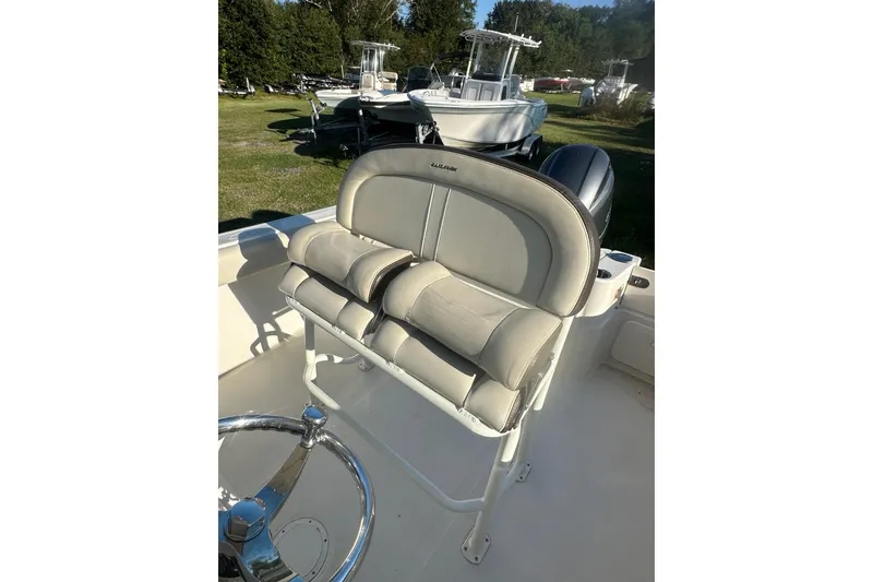 Slide: The Image of 2023 Sailfish 220 CC boat interior with cushioned seating and steering wheel. - 28