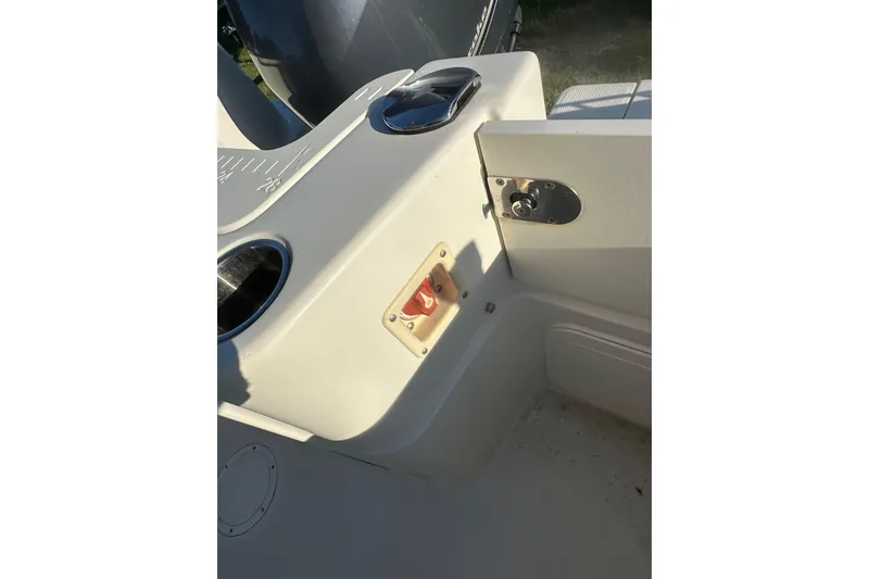 Slide: The Image of 2023 Sailfish 220 CC boat interior detail with control panel and storage compartment. - 29