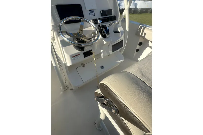 Slide: The Image of 2023 Sailfish 220 CC boat cockpit with steering wheel and controls. - 30