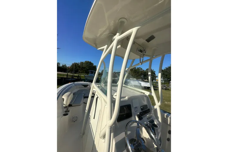Slide: The Image of 2023 Sailfish 220 CC boat console and seating under clear blue sky. - 31