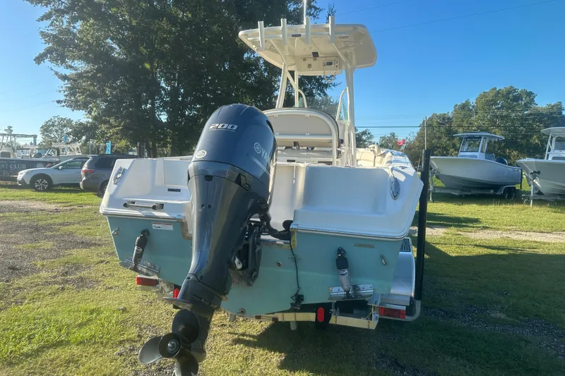 Slide: The Image of 2023 Sailfish 220 CC boat with Yamaha 200 engine, parked outdoors. - 5