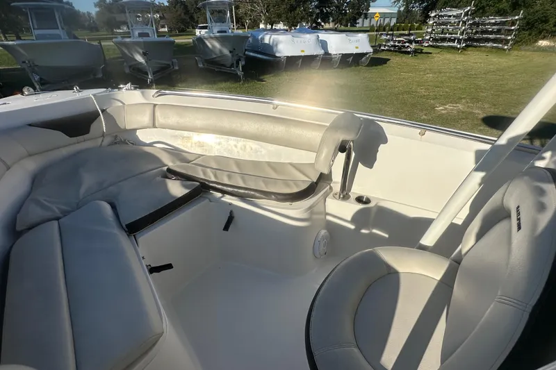 Slide: The Image of 2023 Sailfish 220 CC boat interior with cushioned seating and cup holder. - 9