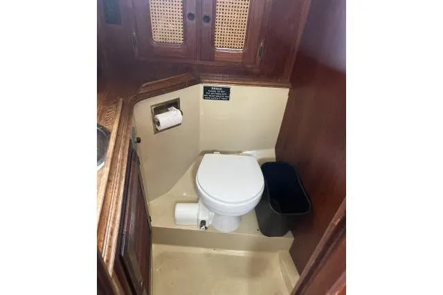 Slide: The Image of 1977 Islander 36 yacht bathroom with wooden cabinets and compact toilet. - 10