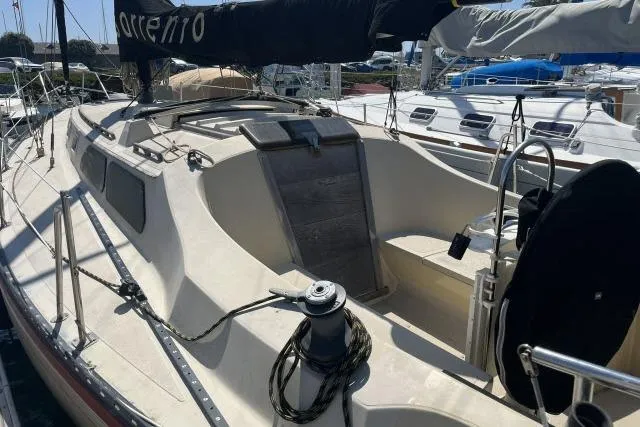 Slide: The Image of 1977 Islander 36 sailboat with a spacious cockpit, docked at a marina. - 11