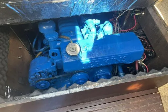 Slide: The Image of Blue engine of a 1977 Islander 36 sailboat, partially enclosed, with visible wiring. - 18