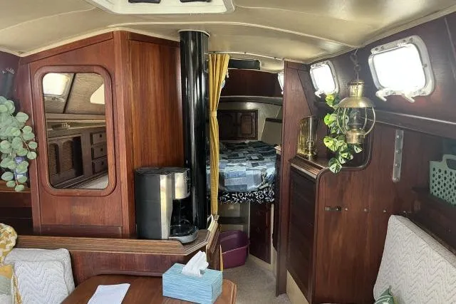 Slide: The Image of Interior of a 1977 Islander 36 sailboat with wood paneling and cozy cabin decor. - 2