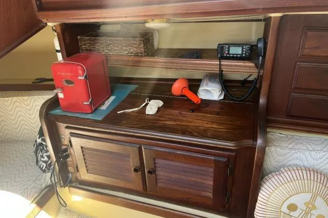 Slide: The Image of 1977 Islander 36 interior with wooden cabinetry, red appliance, and communication equipment. - 4