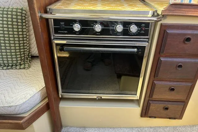 Slide: The Image of 1977 Islander 36 yacht interior with vintage stove and wooden cabinetry. - 7