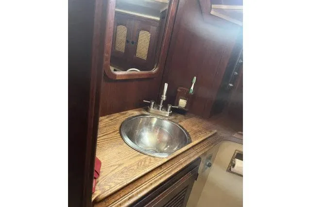 Slide: The Image of 1977 Islander 36 yacht interior with wooden cabinetry and stainless steel sink. - 9