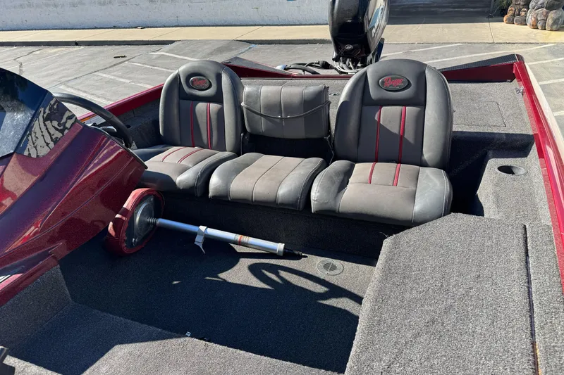 Slide: The Image of 2016 Ranger RT178 boat interior with gray and red seats, steering wheel, and carpeted flooring. - 13