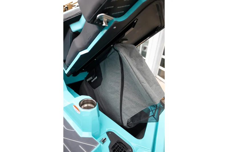 Slide: The Image of 2026 MasterCraft X24 boat interior storage compartment with cup holder and seat detail. - 12