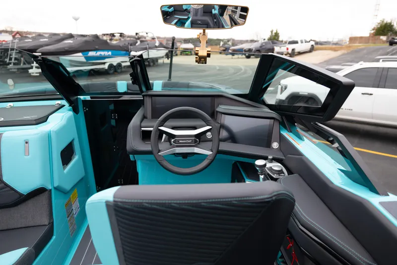 Slide: The Image of Interior view of 2026 MasterCraft X24 boat, featuring modern dashboard and steering wheel. - 21