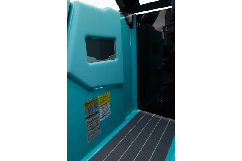 Slide: The Image of Interior view of 2026 MasterCraft X24 boat, featuring teal upholstery and safety labels. - 40