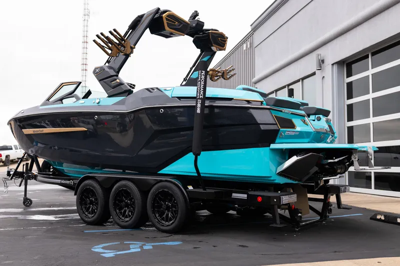 Slide: The Image of 2026 MasterCraft X24 boat on trailer, sleek design, vibrant blue and black color scheme. - 5