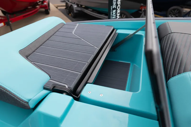Slide: The Image of 2026 MasterCraft X24 boat interior with teal and black seating and storage compartment. - 57