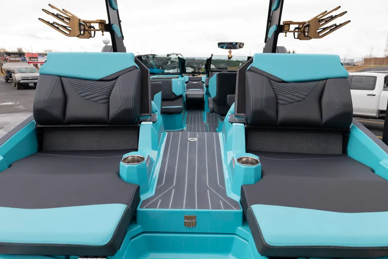 Slide: The Image of 2026 MasterCraft X24 boat interior with turquoise and black seating, cup holders, and sleek design. - 59