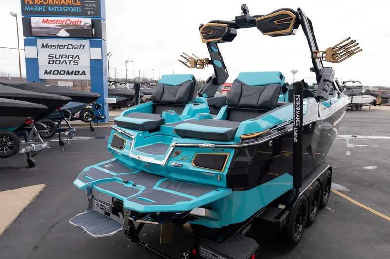 Slide: The Image of 2026 MasterCraft X24 boat in showroom, featuring sleek design and vibrant turquoise color. - 62