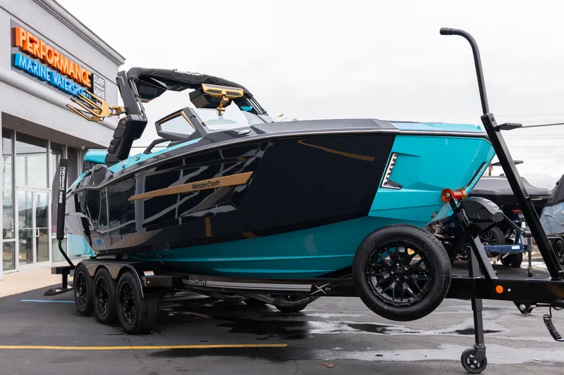 Slide: The Image of 2026 MasterCraft X24 boat on trailer at Performance Marine Watersports dealership. - 63