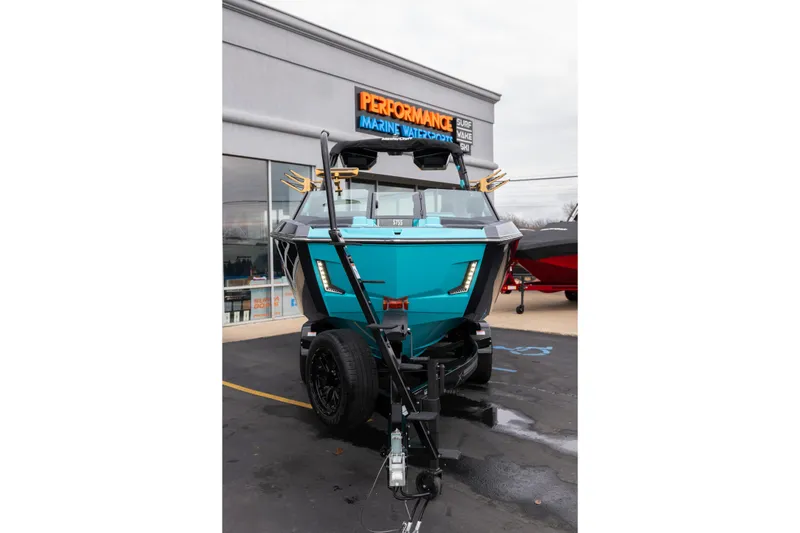 Slide: The Image of 2026 MasterCraft X24 boat in turquoise, parked outside Performance Marine Watersport store. - 64