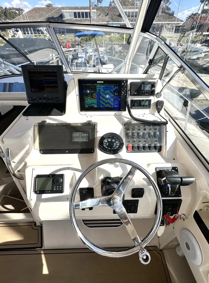 Slide: The Image of 2003 Grady-White Marlin 300 boat dashboard with navigation equipment and steering wheel. - 10