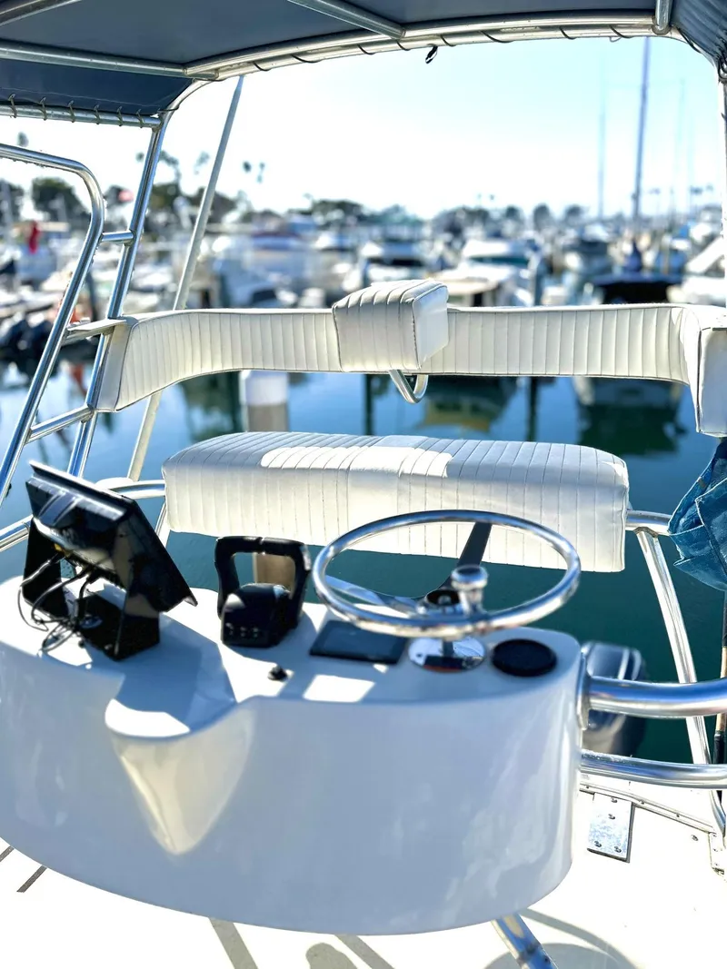Slide: The Image of 2003 Grady-White Marlin 300 boat helm with marina view in background. - 14