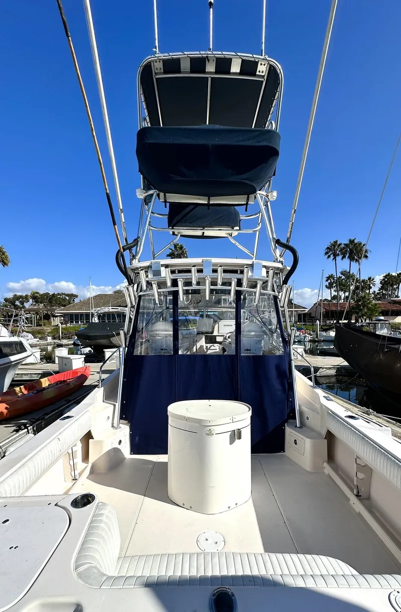 Slide: The Image of 2003 Grady-White Marlin 300 boat with tower and blue canopy in marina. - 23