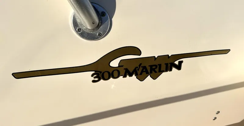 Slide: The Image of 2003 Grady-White Marlin 300 boat logo on white surface. - 8