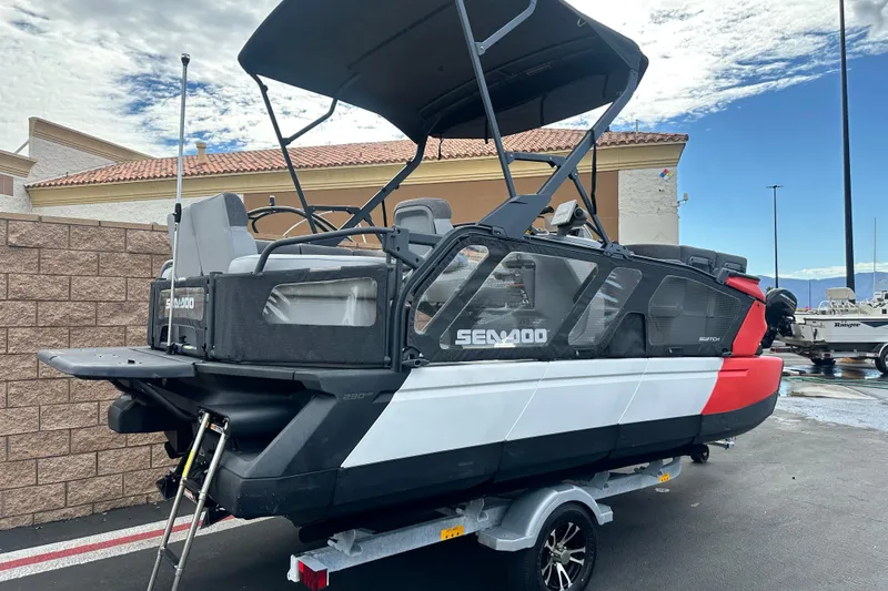 Slide: The Image of 2023 Sea-Doo Switch Cruise 18 in vibrant red, parked on a trailer. - 2