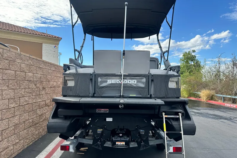 Slide: The Image of 2023 Sea-Doo Switch Cruise 18 pontoon boat, rear view with ladder and canopy. - 4