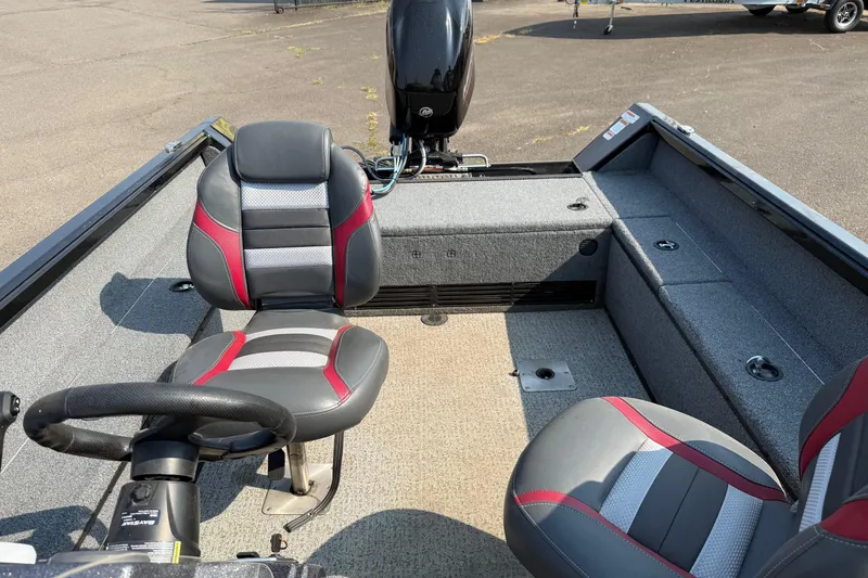 Slide: The Image of 2023 Ranger VS1665SC boat interior with gray and red seating, steering wheel, and motor. - 15
