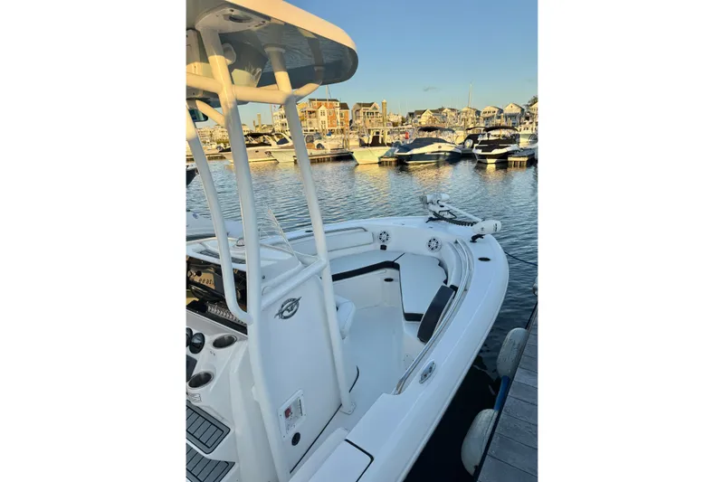 Slide: The Image of 2021 Tidewater 210 LXF boat docked at marina with other vessels in background. - 24