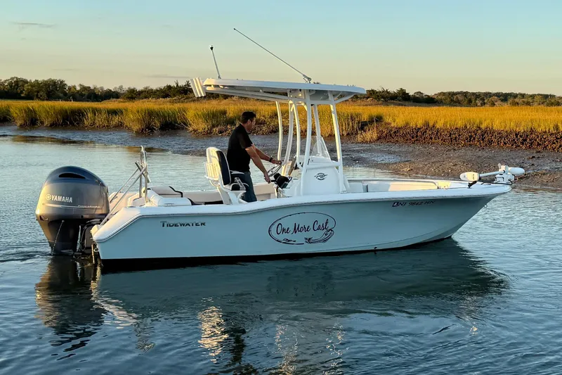 The Image of 2021 Tidewater 210 LXF boat on trailer, parked outdoors under clear blue sky. - 0