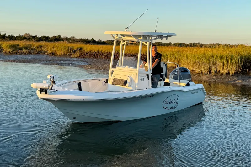 Slide: The Image of 2021 Tidewater 210 LXF boat docked at marina with other vessels. - 6