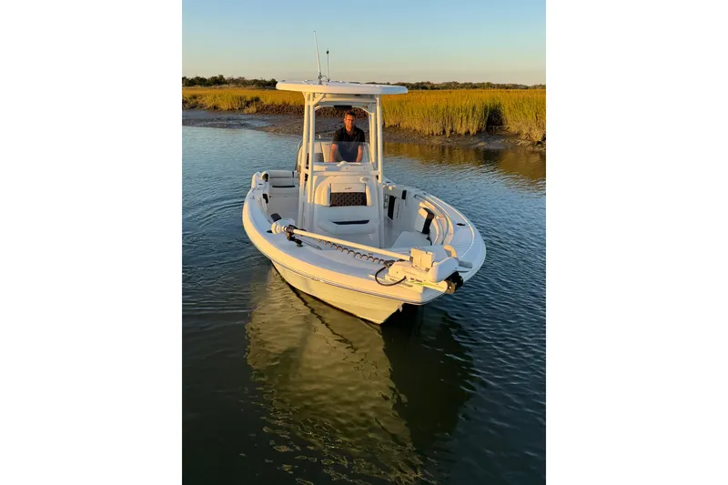 Slide: The Image of 2021 Tidewater 210 LXF boat interior with modern dashboard and steering, docked at marina. - 7