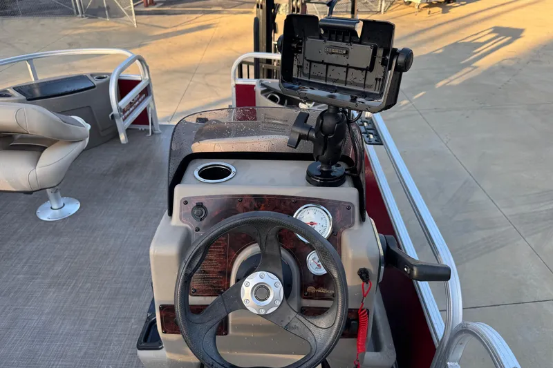 Slide: The Image of 2022 Sun Tracker Bass Buggy 18 DLX boat dashboard with steering wheel and mounted device holder. - 3